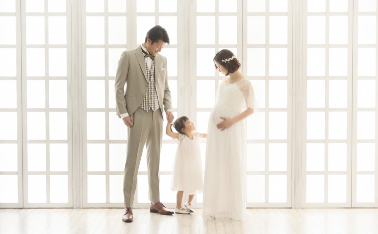 妊婦さんがお腹に手を添えて見つめている写真