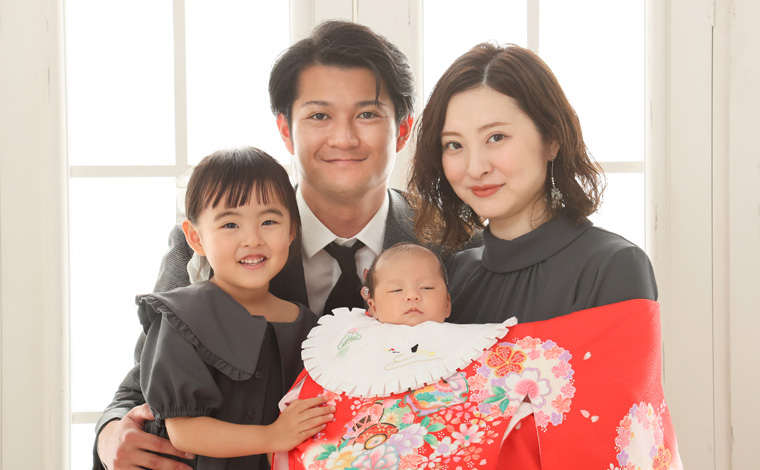 家族みんなで赤ちゃんを見つめる